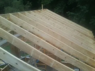 New roof rafters set over an addition before sheathing in Hope Valley